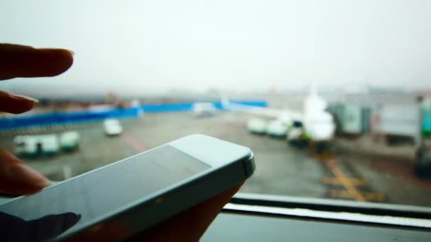 Жінка використовує смартфон в аеропорту — стокове відео