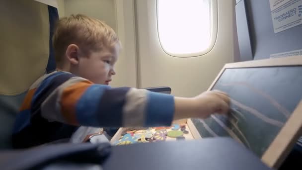 Garçon dans l'avion dessin à bord avec de la craie — Video