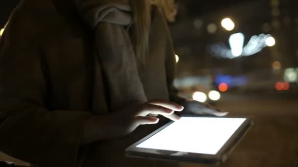 Mujer caminando por la calle de la noche y usando tableta — Vídeos de Stock