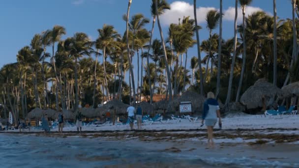 Gente caminando por la playa en un resort tropical — Vídeos de Stock