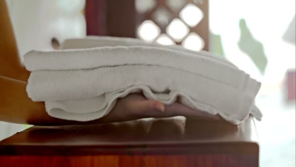 Vrouw schone handdoeken en bloem te zetten van de tabel — Stockvideo