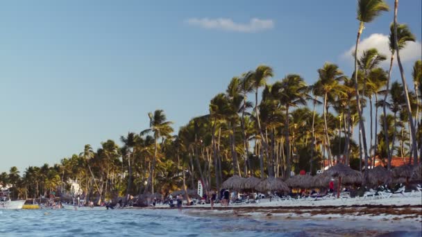 Тропічний курорт з людьми на пляжі, човни, вітрильний спорт — стокове відео