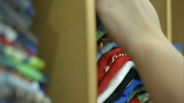 Mujer mirando sobre la pila de materiales en la tienda — Vídeos de Stock