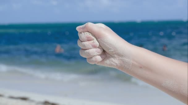 Sand hälla från kvinnlig hand — Stockvideo