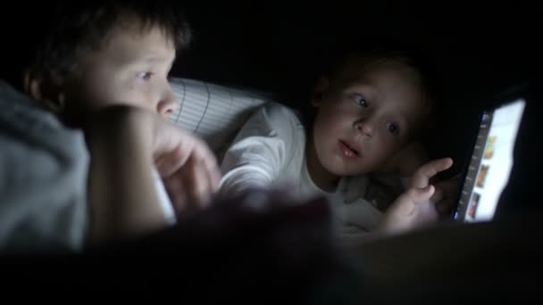 Dois meninos tentam assistir o filme à noite usando o tablet — Vídeo de Stock