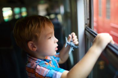 Küçük çocuk oyuncak tren pencereden dışarı bakıyor