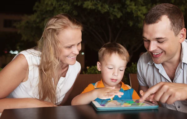 Familj på tre tillbringa tid i café med tablet PC — Stockfoto