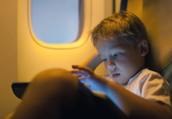 Kleine jongen met behulp van tablet pc tijdens de vlucht — Stockfoto