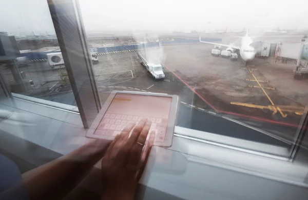 Женщина работает с планшетным ПК в терминале аэропорта — стоковое фото
