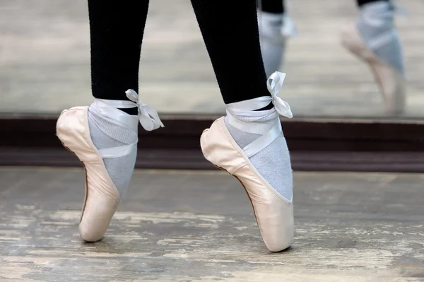 Vue rapprochée des jambes de ballerines en pointes sur le sol en bois — Photo