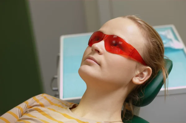 Vrouw in rode veiligheidsbril in tandheelkundige kantoor — Stockfoto