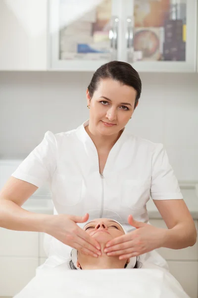 Cosmético en salón de tratamiento de belleza haciendo un masaje facial — Foto de Stock