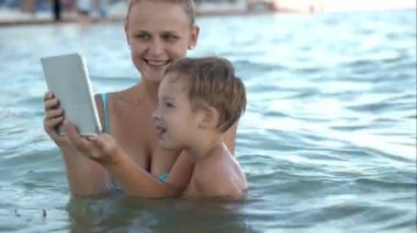 Anne pad ile onun oğlu fotoğrafı veya videoyu gösterir suda