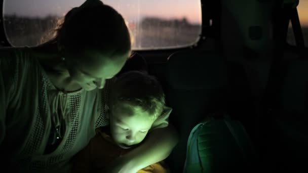 Moeder en zoon touch gebruikt pad in auto 's nachts — Stockvideo