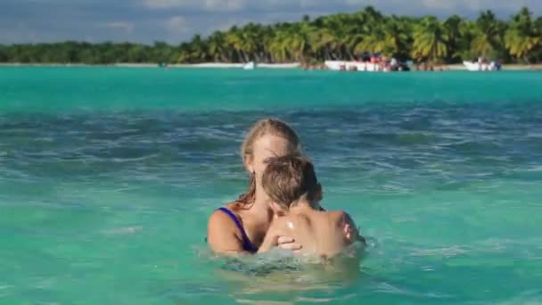 Mother and son playing in clear sea water — Stock Video