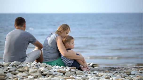 La famille est assise sur la plage — Video