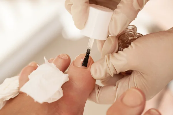 Применение лака для ногтей во время педикюра в салоне красоты — стоковое фото