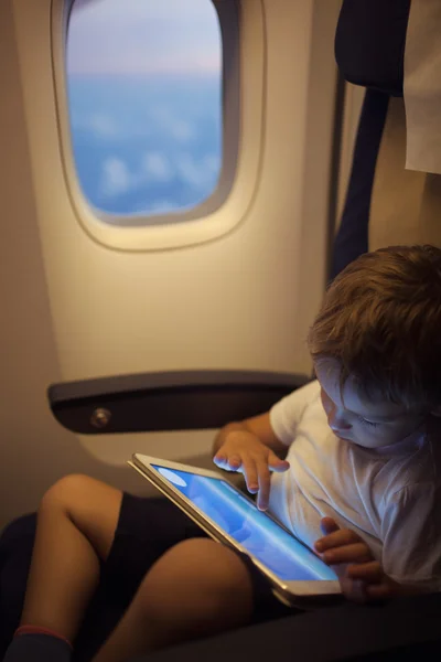 Chico pasar tiempo con la tableta PC durante el vuelo —  Fotos de Stock