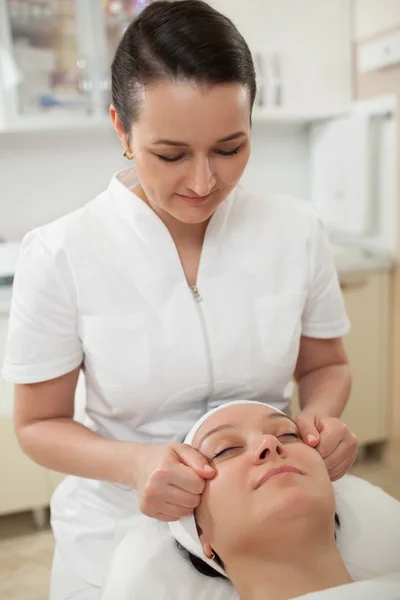 Woman under facial massage at beauty spa — Stock Photo, Image