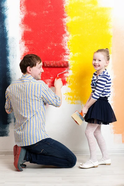 Muchacha feliz pintura pared con padre — Foto de Stock