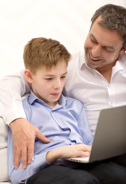 Father watching son working with laptop — Stock Photo, Image