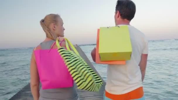 Amigável jovem casal andando no cais depois de fazer compras — Vídeo de Stock