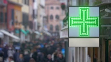 Yoğun caddede yeşil haçlı eczane tabelası