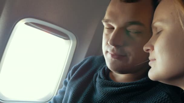 Slaperige man en zijn vriendin in het vliegtuig — Stockvideo