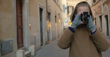 Sokakta retro kamera kullanan bir kadın