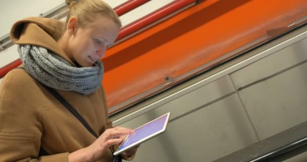 Kvinna på rulltrappan med hjälp av surfplatta dator — Stockvideo