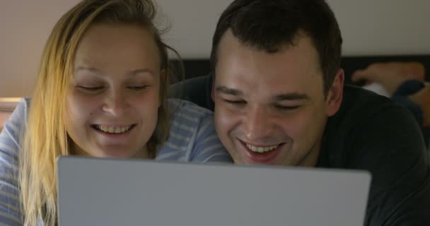 Couple watching humorous video on laptop — Stock Video