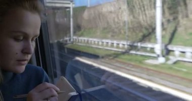 Woman making sketches during train ride