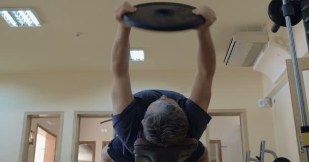 Exercice avec levage de la plaque de poids couché sur le banc — Video