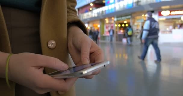 Kvinnliga händer som använder mobiltelefon på stationen — Stockvideo