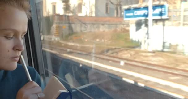 Woman taking notes or drawing in train — Stockvideo