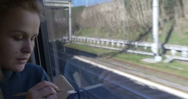 Woman making sketches during train ride — Stock video