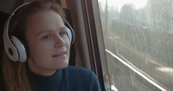 Woman traveling by train with favorite muisc — Stockvideo