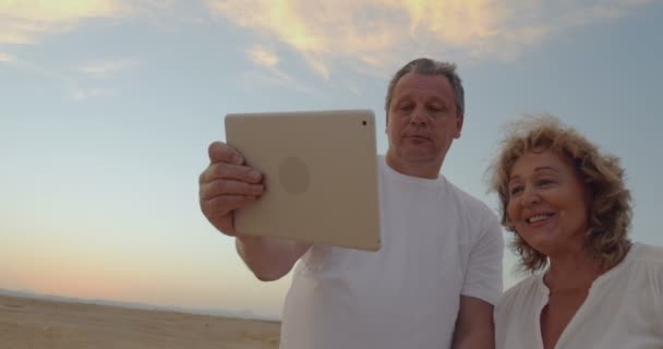 Casal sênior usando touch pad ao ar livre em férias — Vídeo de Stock