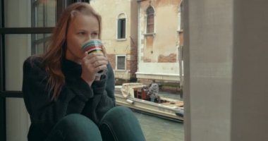 Venedik 'te evde kahve içen hasretli bir kadın.