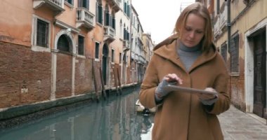 Woman wandering in Venice with pad
