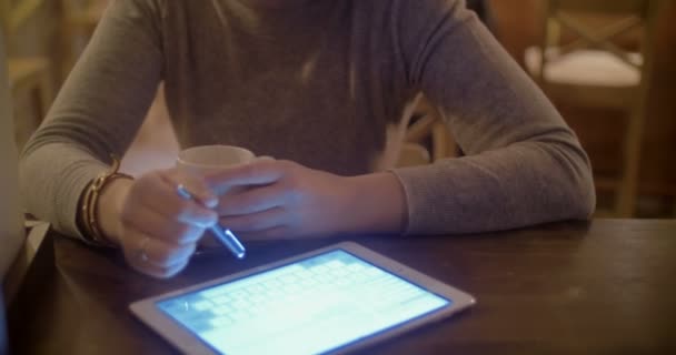 Woman with pad and tea in cafe — Stockvideo