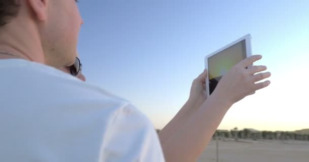 Jongeren op het strand schieten zonsondergang met pad — Stockvideo