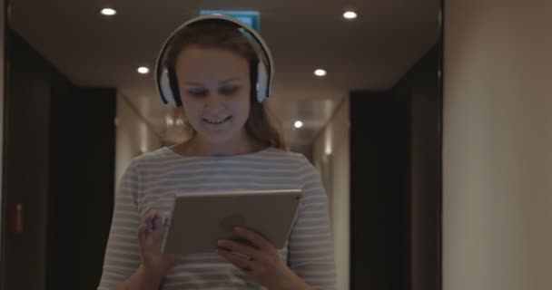 Woman with pad enjoying music in headphones — Stok video