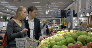 Süpermarkette elma seçen gençler