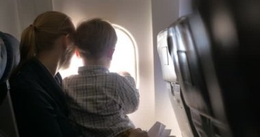 Anne ve oğul uçakta aydınlatma gözlüyor.