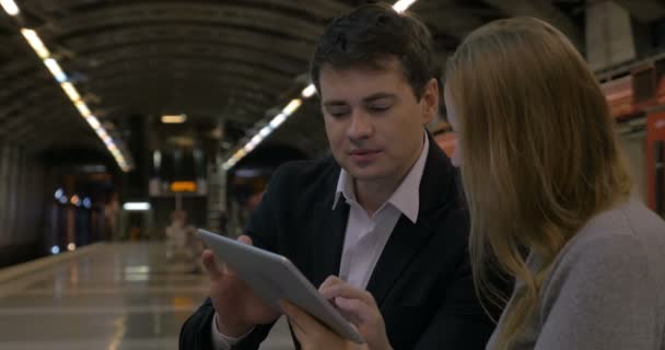 Uomo e donna che passano il tempo con touch pad nel sottosuolo — Video Stock