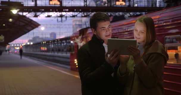 Hombre y mujer con almohadilla en la estación — Vídeo de stock
