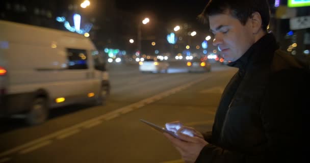 Şehirdeki işlek yolda dokunmatik ped kullanan bir adam. — Stok video