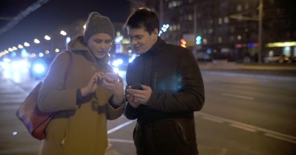 Young people using cells and talking in the street — Stock Video