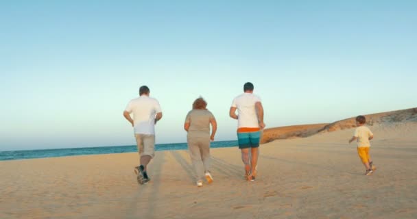 Famille courant à la mer le soir — Video